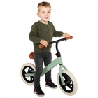Young child riding a matte green Cheqo® loopfiets with EVA tires, ideal for developing balance at ages 1-4.