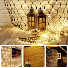 Warm white Cheqo® net lighting with 320 LED lights illuminating indoor and outdoor spaces, featuring a festive ambiance.