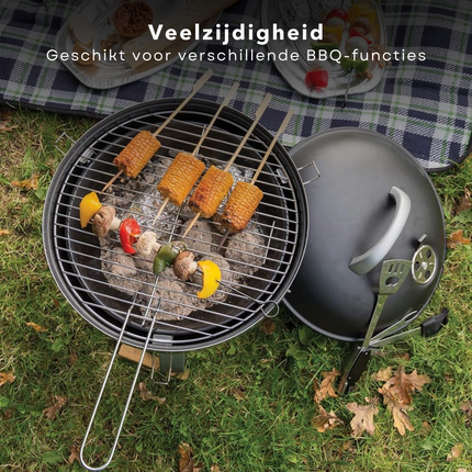 Compact barbecue with skewers of vegetables and corn, showcasing versatility for various BBQ functions on grass.