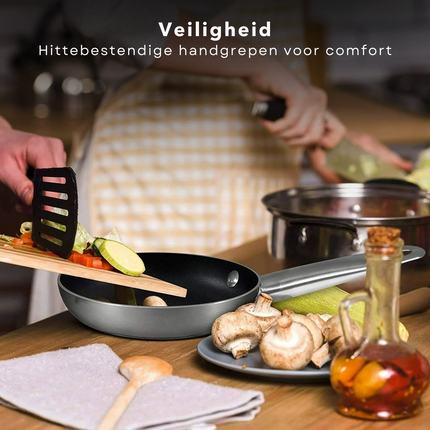 Cheqo koekenpannenset met hittebestendige handgrepen in gebruik tijdens het koken met verse ingrediënten in een keuken.