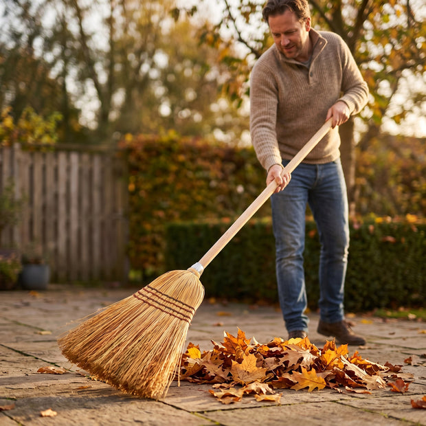 Herfstbladeren vegen met een strobezem